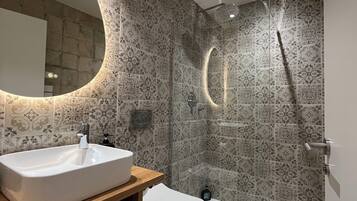 Deluxe tweepersoonskamer | Badkamer | Een douche, een haardroger, handdoeken, zeep