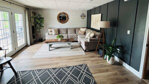 Una sala de estar moderna con un sofá, una mesa de centro y un espejo grande en la pared.