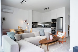 Solara 101 | Living room | 50-inch Smart TV with digital channels, Netflix, streaming services - Solara - Stylish Balcony Apartments in Larnaca (Larnaca)