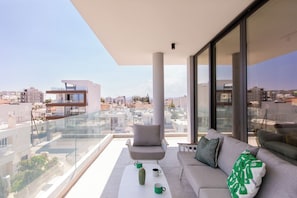 A modern balcony with a sofa, a coffee table, and a cactus. - Solara - Stylish Balcony Apartments in Larnaca (Larnaca)