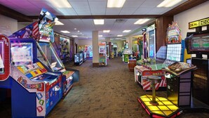 Una fila di giochi arcade in una stanza con pavimenti in moquette e pareti in legno.