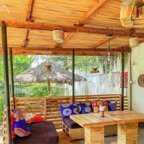 Ein Sitzbereich im Freien mit Holzbänken und einem Tisch, umgeben von einer Holzpergola.