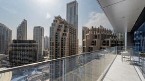 Ein Hochhaus mit einem Glasbalkon und Blick auf die Stadtlandschaft.