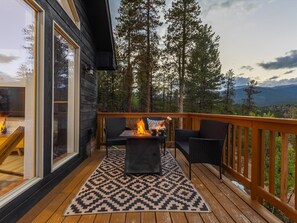 A deck with a fire pit, outdoor furniture, and a view of a forest and mountains. - Geo Dome Group Retreat | 3 King Beds & Game Room (Bailey)