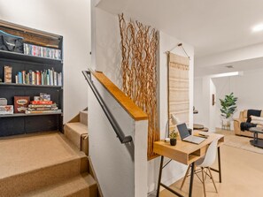 On the way downstairs you pass the full library wall stacked with games, books, and movies. The fun at Lakeview Lodge starts before you even hit the bottom step. - Geo Dome Group Retreat | 3 King Beds & Game Room (Bailey)