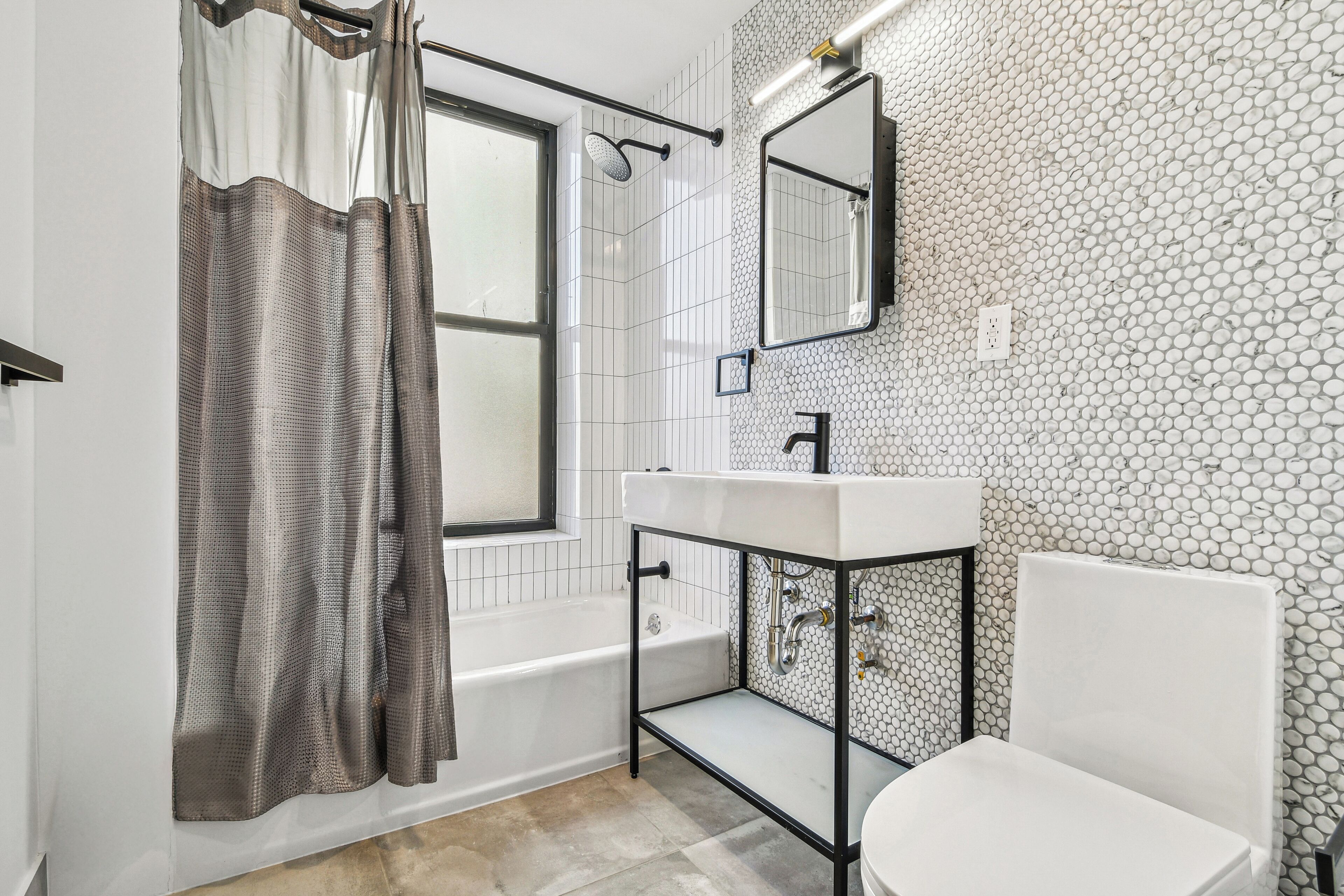 A bathroom with a bathtub, toilet, and sink.