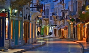 A narrow street lined with buildings featuring balconies and traditional architecture.