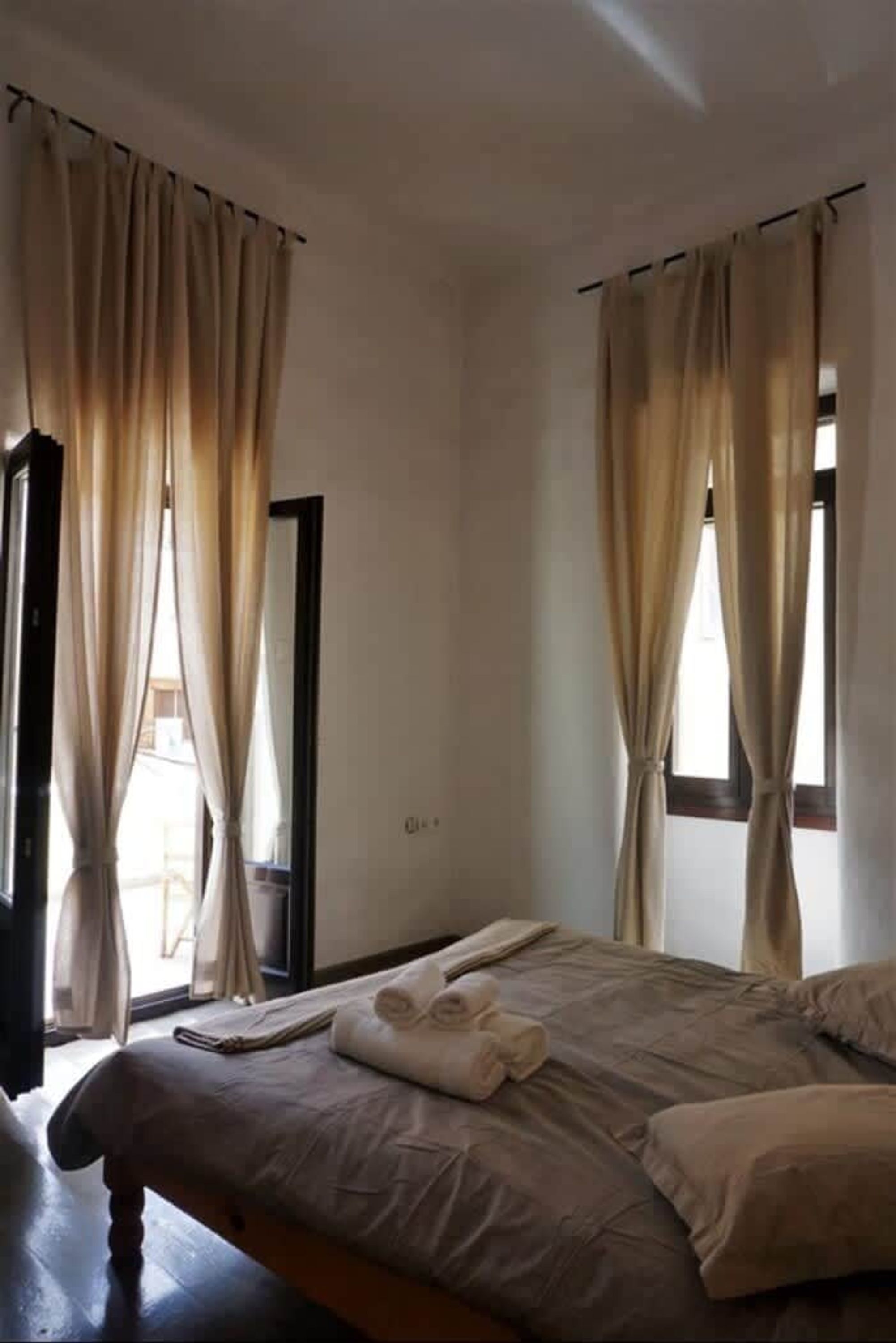 Ein Schlafzimmer mit Bett, Vorhängen und einem Fenster.