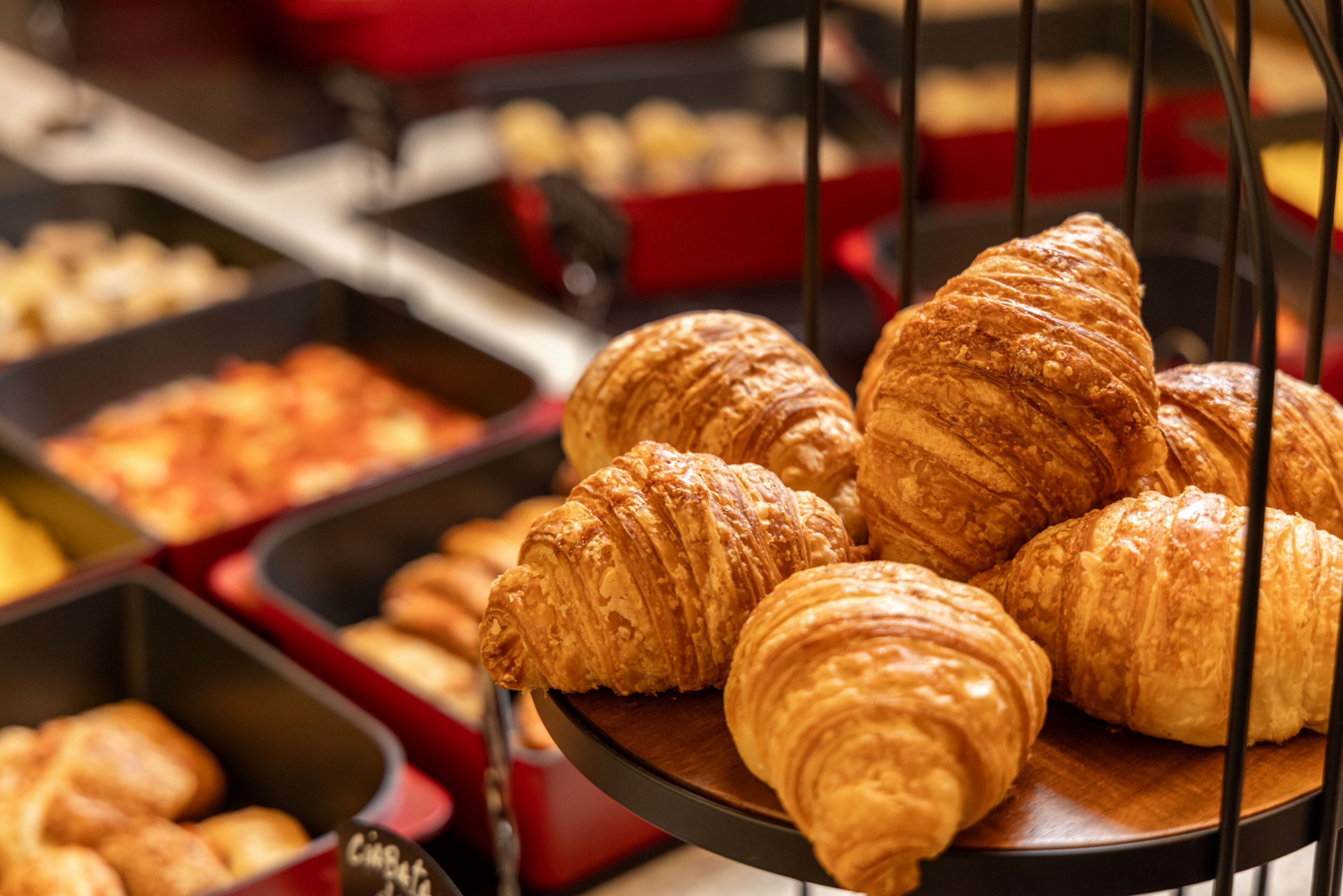 Exposição de croissants e outros produtos de pastelaria numa padaria.