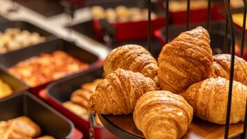 Exposição de croissants e outros produtos de pastelaria numa padaria.