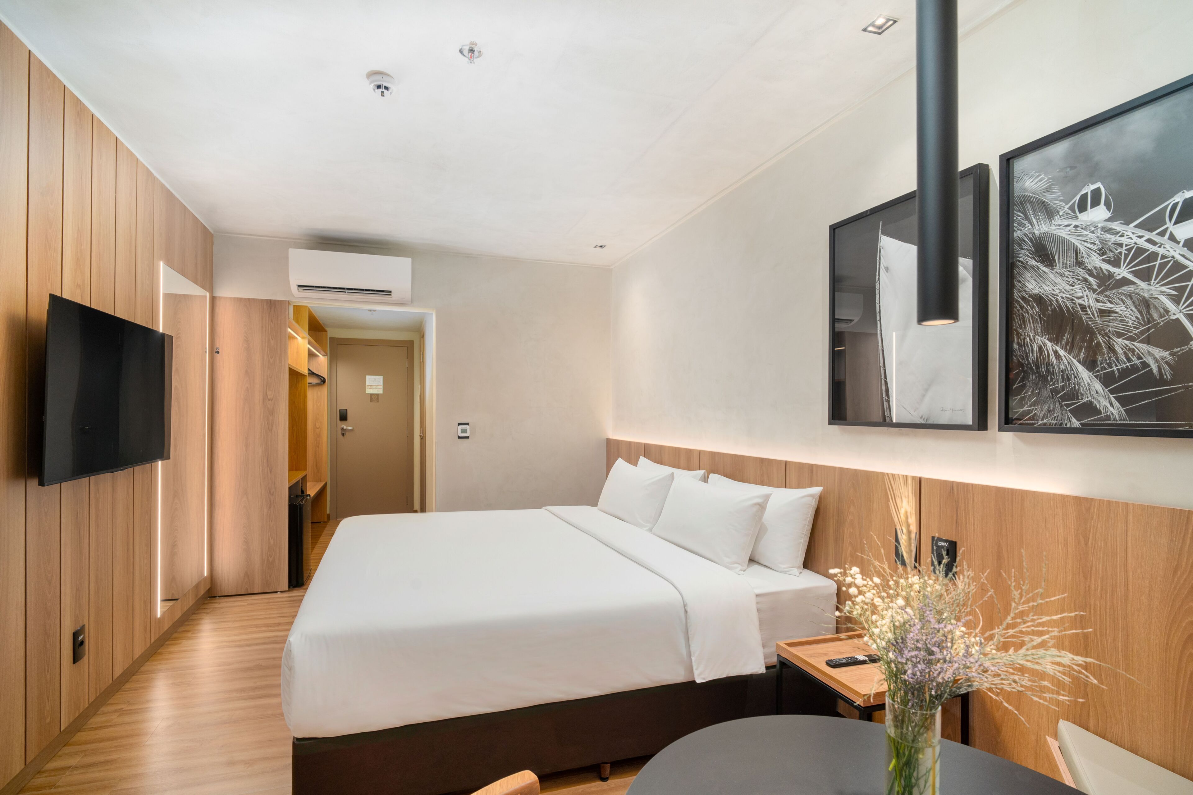 Ein Hotelzimmer mit einem Bett, einem Fernseher, einem Schreibtisch und einem Sessel.