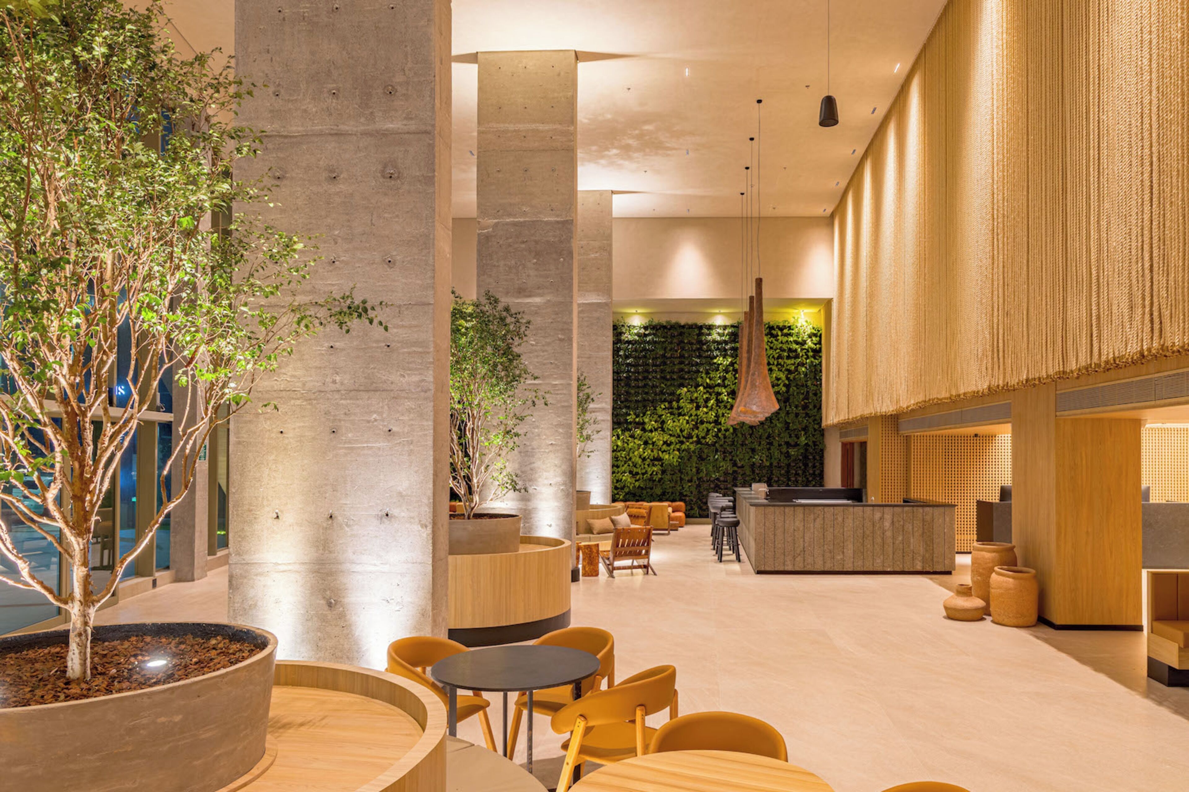 A modern interior with a reception desk, seating area, and a vertical garden wall.