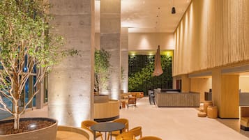 A modern interior with a reception desk, seating area, and a vertical garden wall.