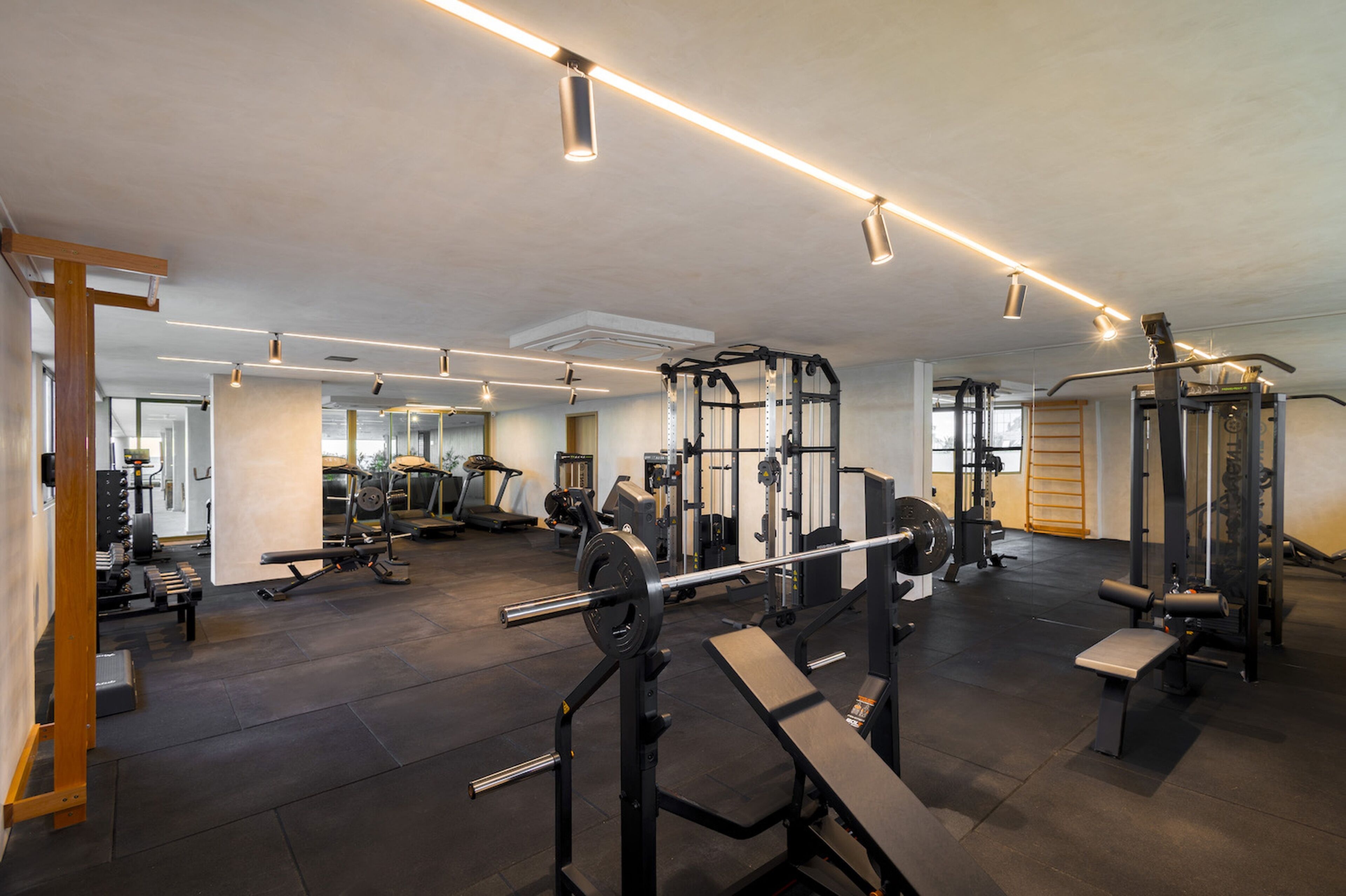 A gym with various exercise equipment, including treadmills, weight machines, and free weights.