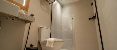 Ein modernes Badezimmer mit einer Duschkabine, einer Toilette und einem Waschbecken.