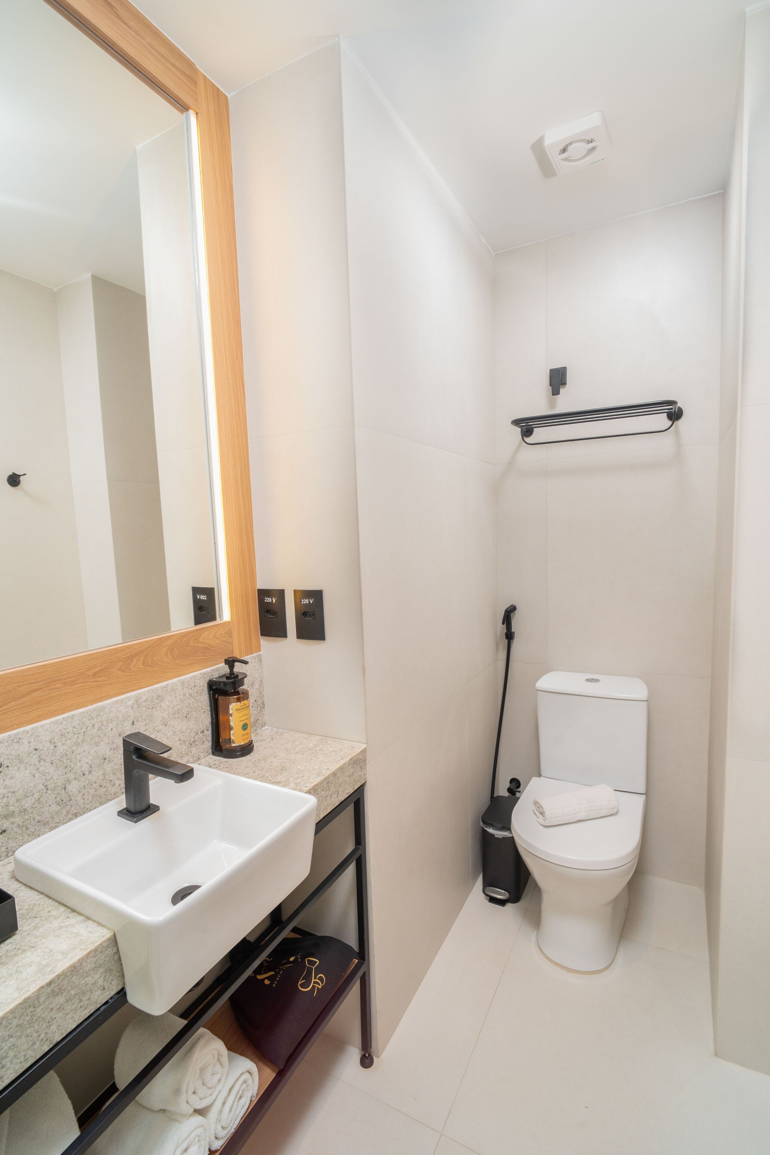Une salle de bain équipée d’un lavabo, d’un miroir, de toilettes et d’une douche.