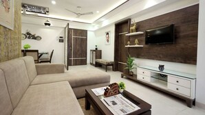 A modern living room with a sofa, coffee table, TV, and decorative items. - 2 Bedroom Apartments (Mumbai)