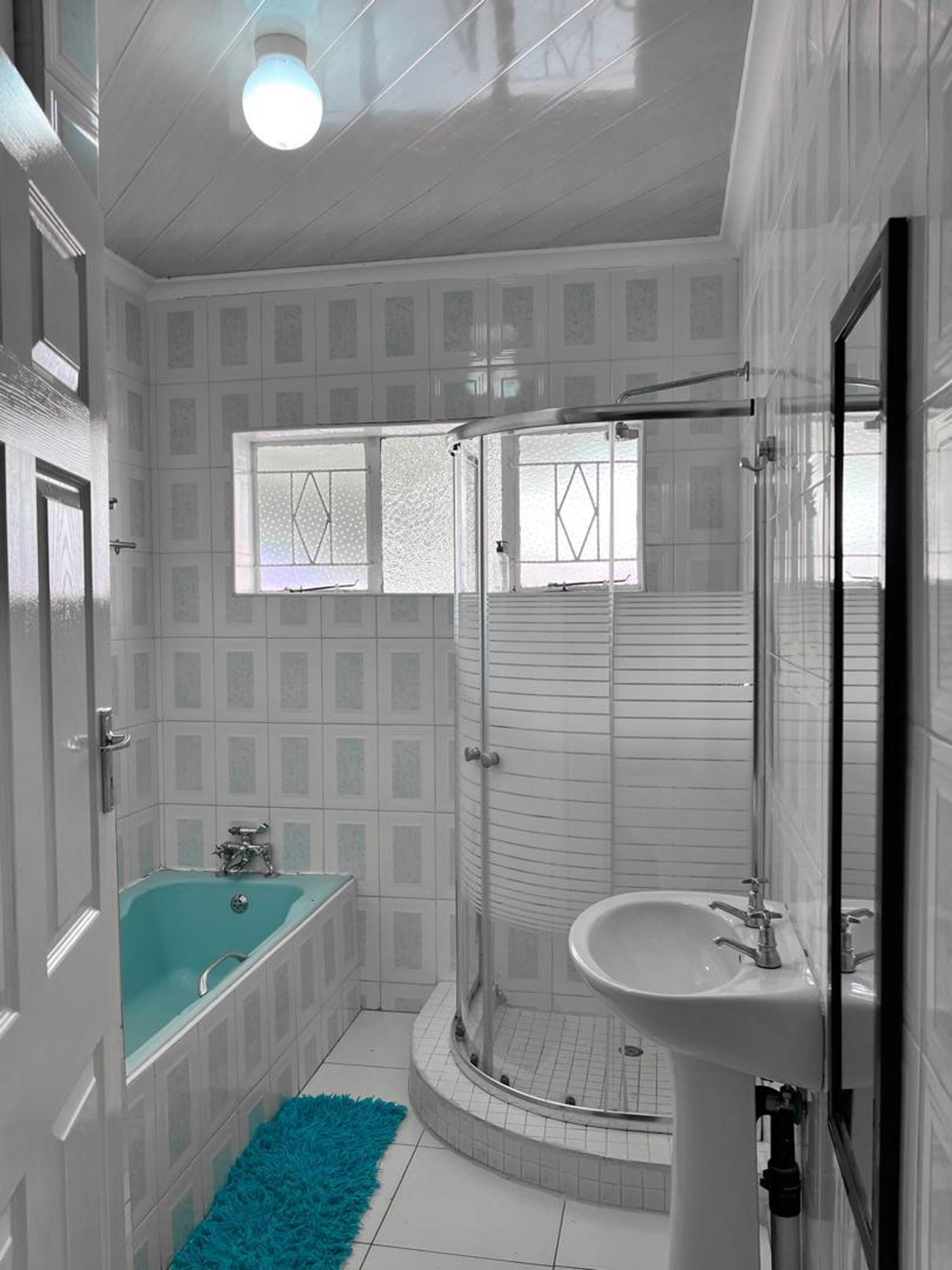 A bathroom with a bathtub, shower, and sink.