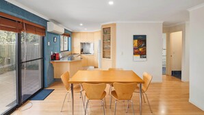 Eine moderne Küche mit Holzausstattung, einem Edelstahlkühlschrank und einem eingebauten Backofen.