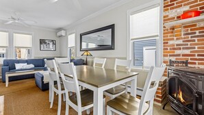 Ein modernes Wohnzimmer mit Essbereich, Kamin und großem Fenster.