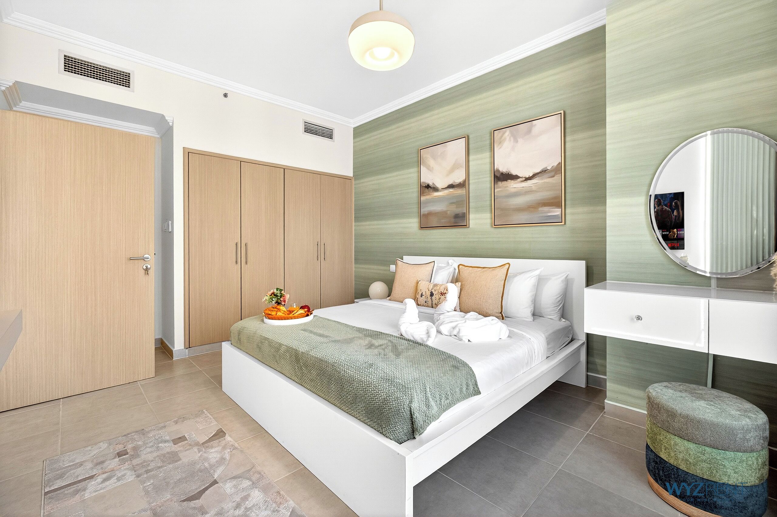 A bedroom with a bed, a dresser, a mirror, and artwork on the wall.