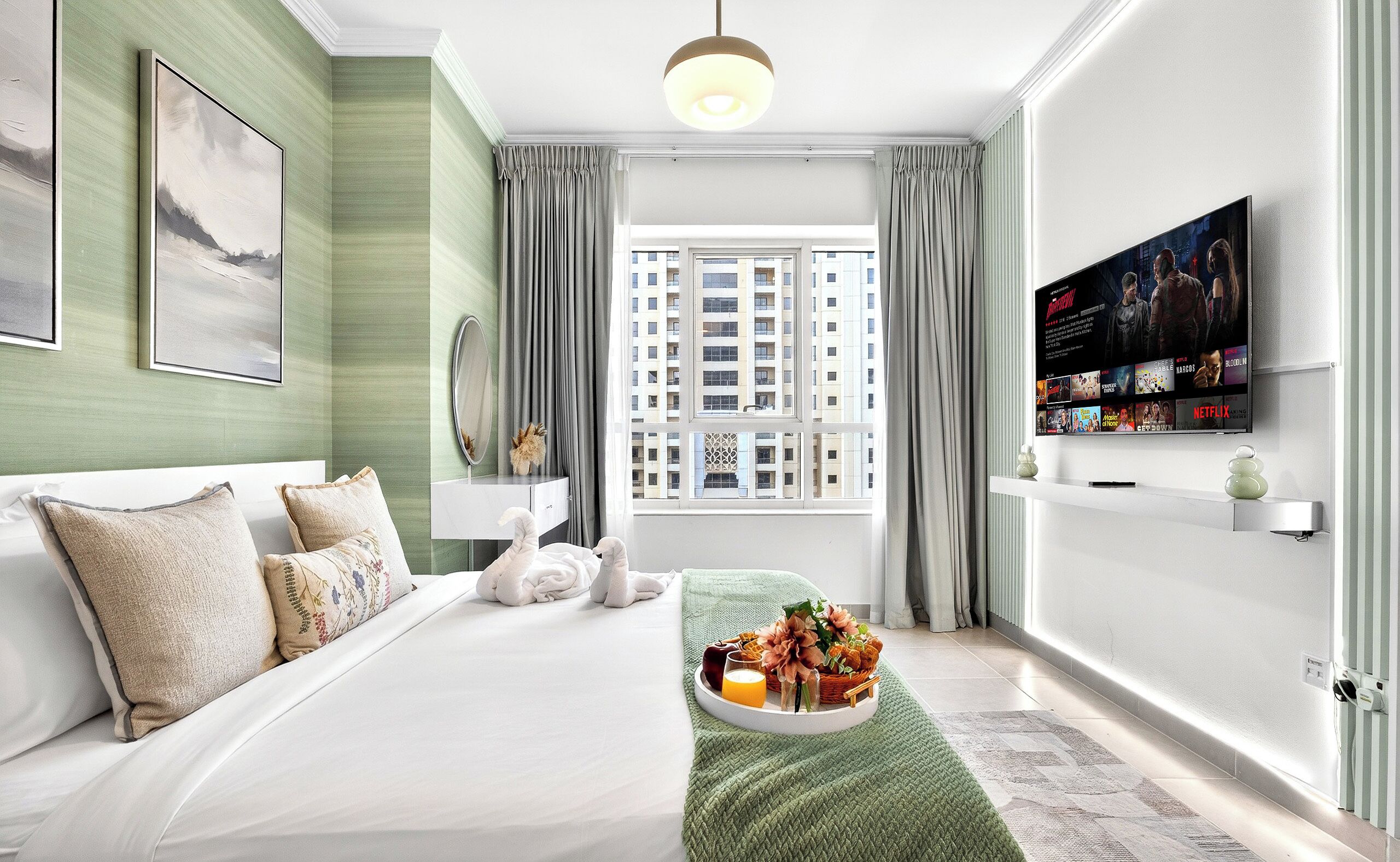 Une chambre d’hôtel moderne avec un grand lit, un téléviseur fixé au mur et une vue sur un immeuble par la fenêtre.