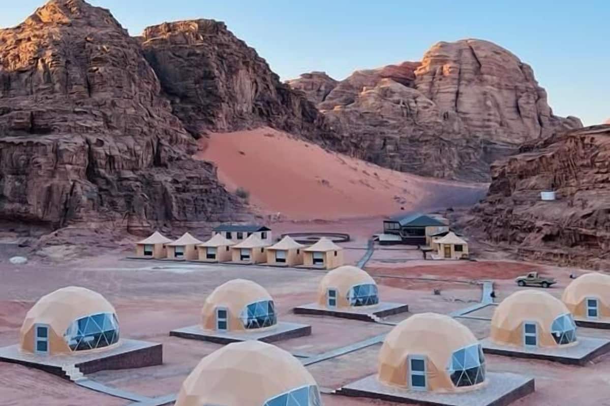 Dome-shaped accommodations with a desert backdrop, arranged in rows with a clear view of the surrounding rocky terrain.