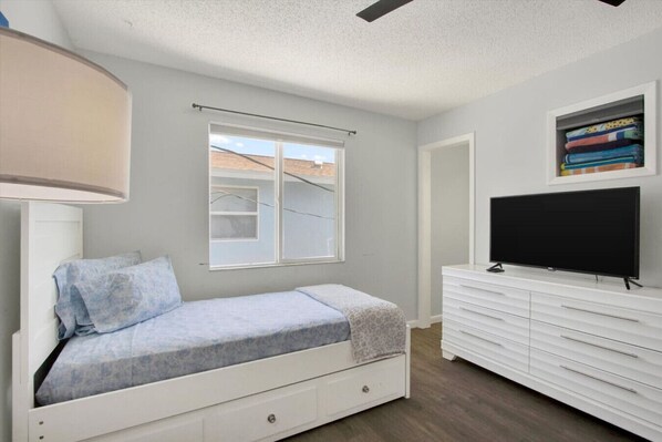 A bedroom with a bed, a TV, a dresser, and a window. - Indian Rocks Oasis – Renovated 2BR Beach Retreat (Indian Rocks Beach)