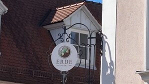 A building corner with a sign for "ERDE HOTEL" and a visible window. - Erde Hotel Erlangen (Erlangen)