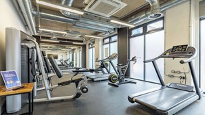 Un gimnasio con cintas de correr, elípticas y equipo de pesas.