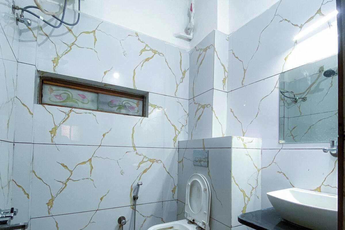 Une petite salle de bain avec des toilettes, un lavabo et une douche.