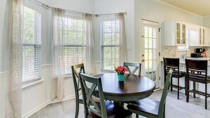 A dining area with a round table, chairs, and a window with curtains. - 10 Mi to Augusta: Georgia Family Home w/ Yard (Augusta)