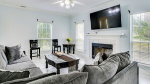 A living room with a fireplace, a flat-screen TV, and a ceiling fan. - 10 Mi to Augusta: Georgia Family Home w/ Yard (Augusta)