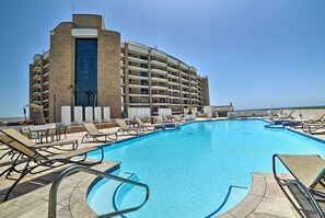 A hotel with a large swimming pool, sun loungers, and a view of the ocean. - 7th-floor Oceanfront Unit w/ Pools in Port Aransas (Port Aransas)
