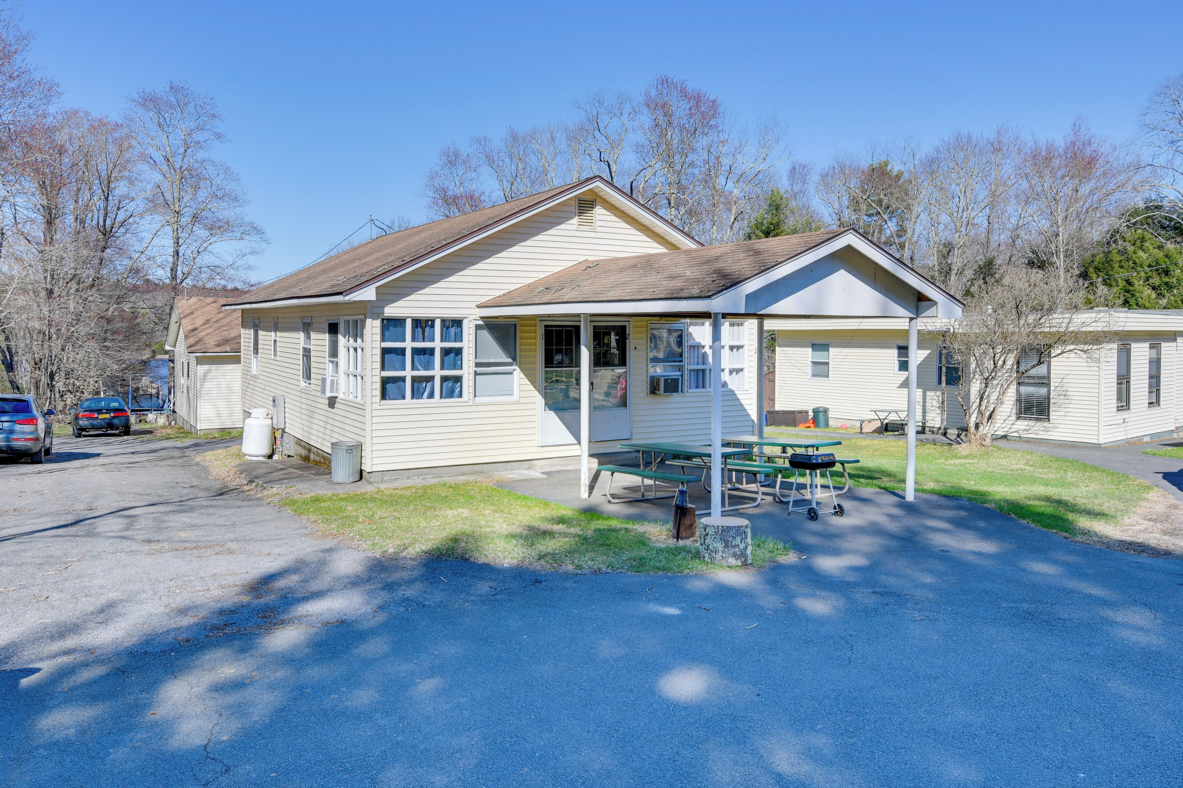 A single-story building with a porch, a picnic table, and a small attached structure.