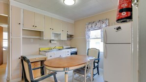 A compact kitchen with a wooden table and chairs, a refrigerator, and a stove. - Shared Boat Launch: Lake Retreat in Ellenville! (Ellenville)