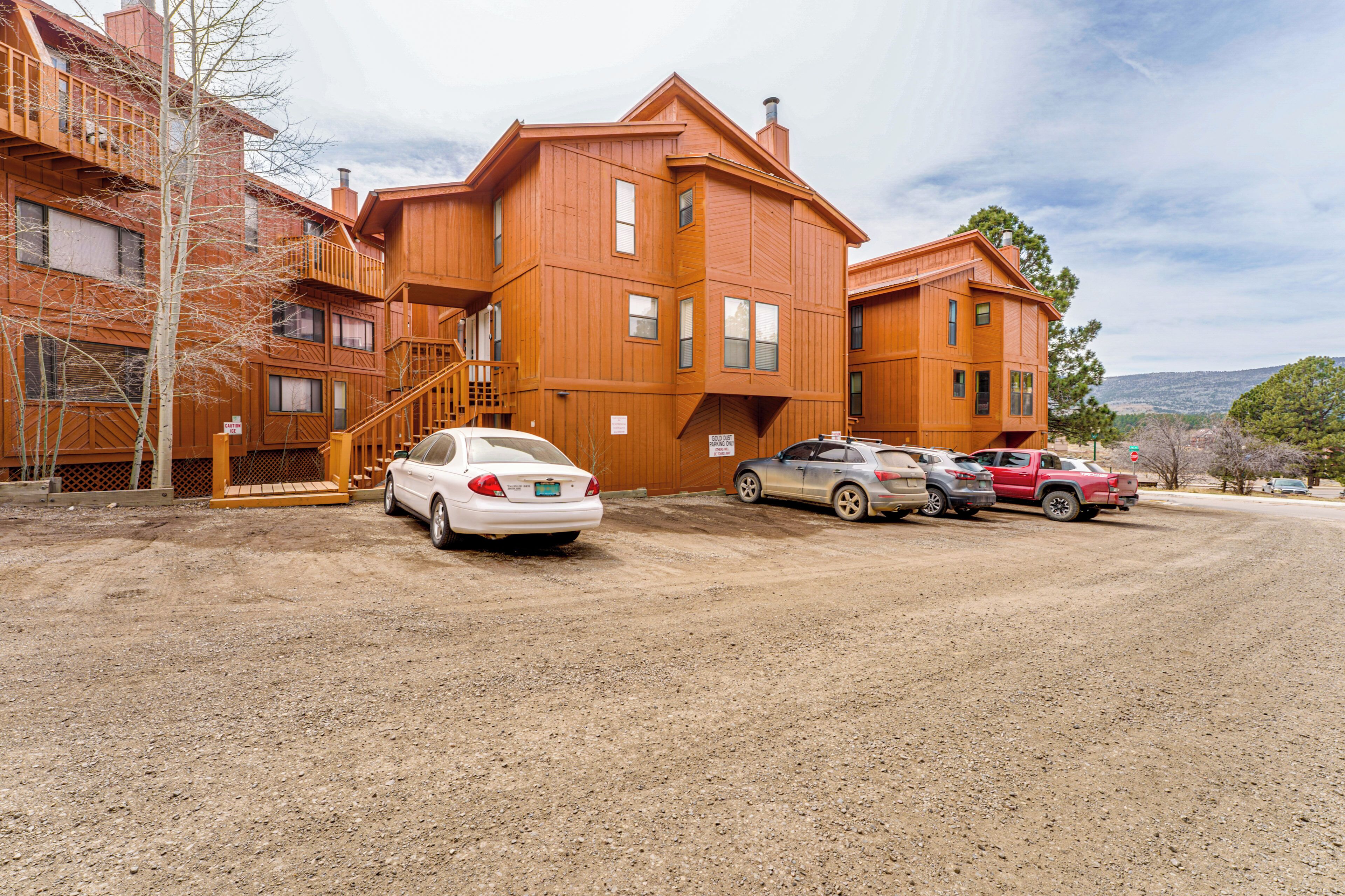 A multi-story wooden building with a dirt ground in front.