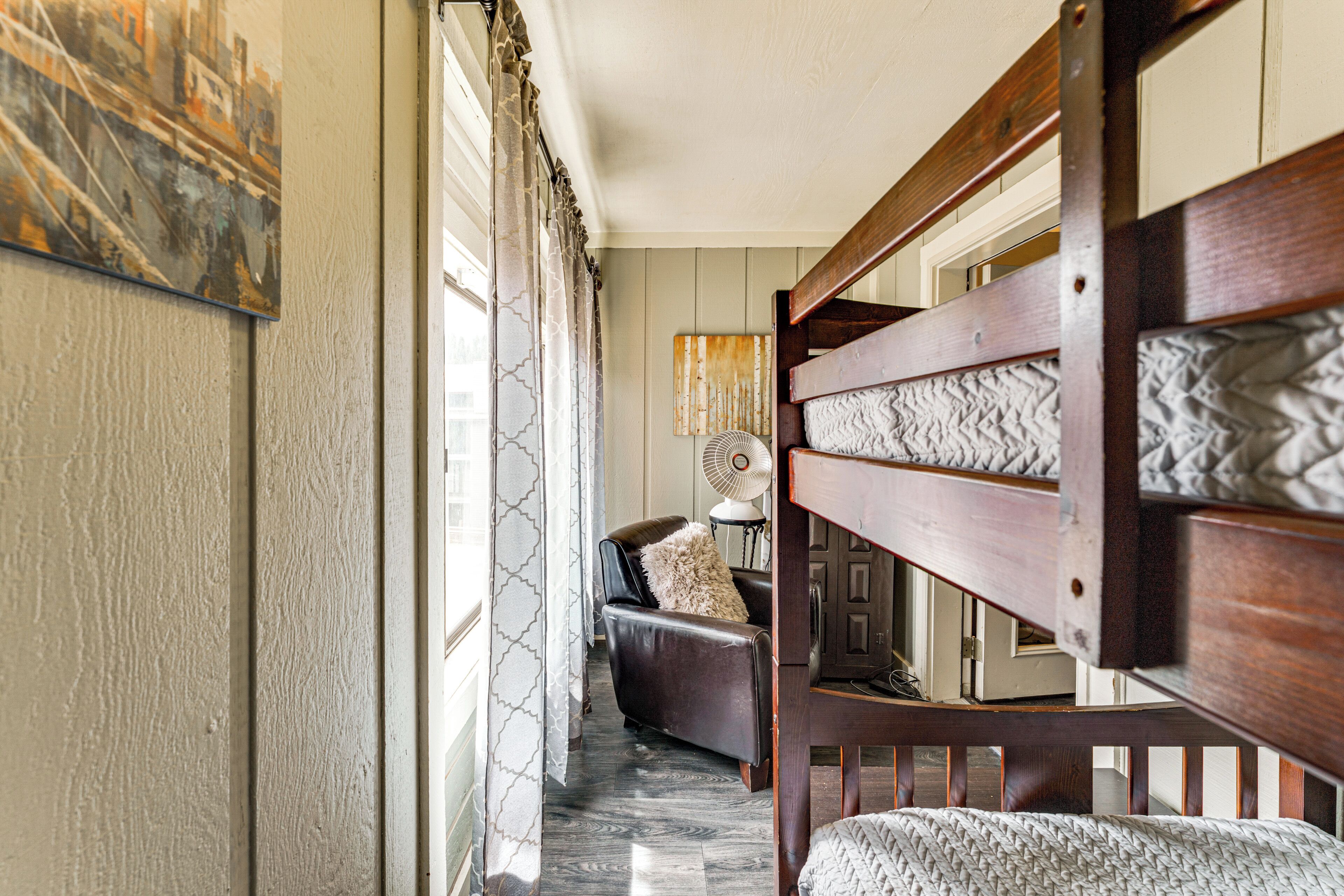 A hallway with a wooden bench, a leather sofa, and a fan.