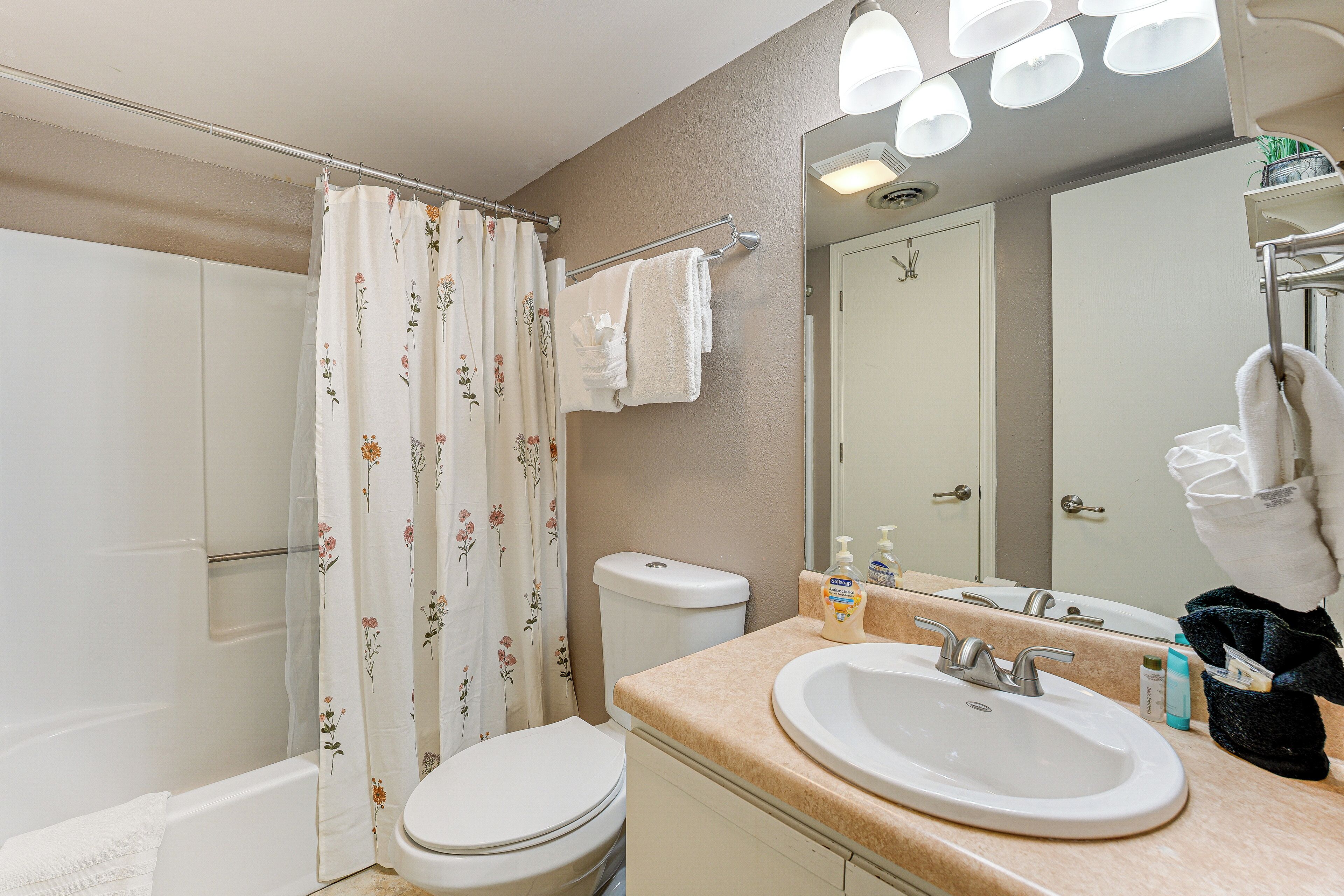 A bathroom with a toilet, sink, and shower.