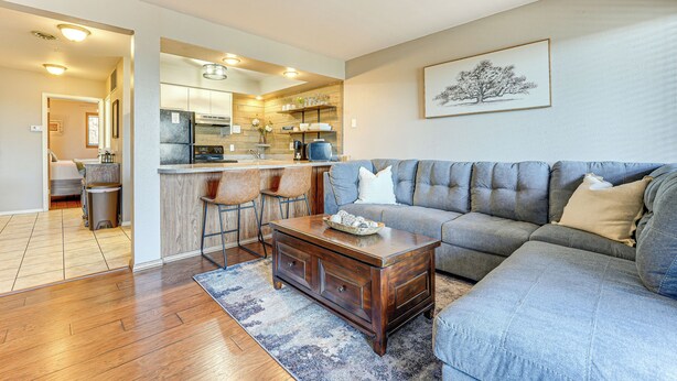 A modern living room with a sectional sofa, a wooden coffee table, and a kitchen in the background. - 2 Mi to Silver Dollar City: Condo in Branson West (Branson West)