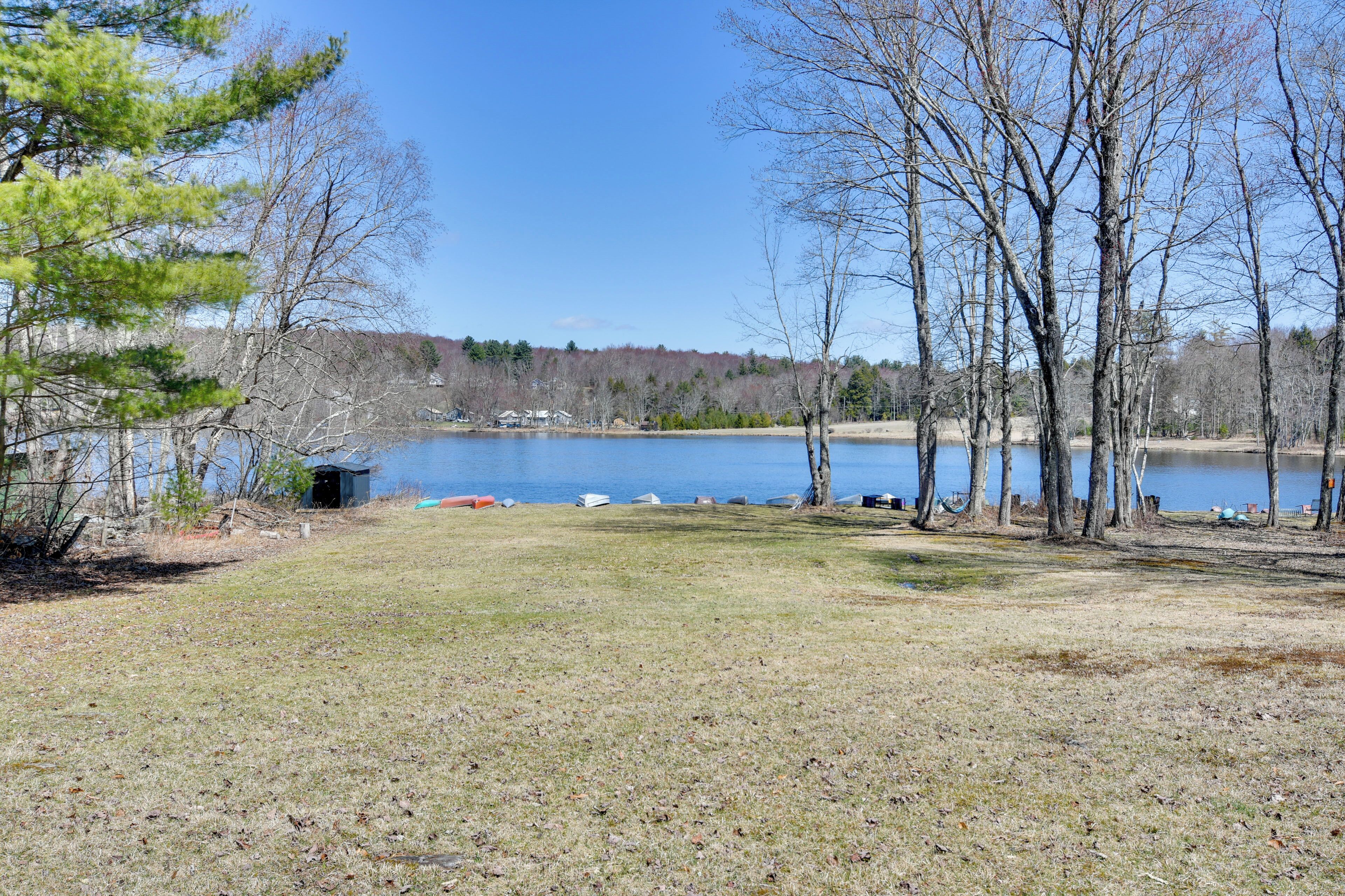 A lakeside campsite with tents and a small shed.
