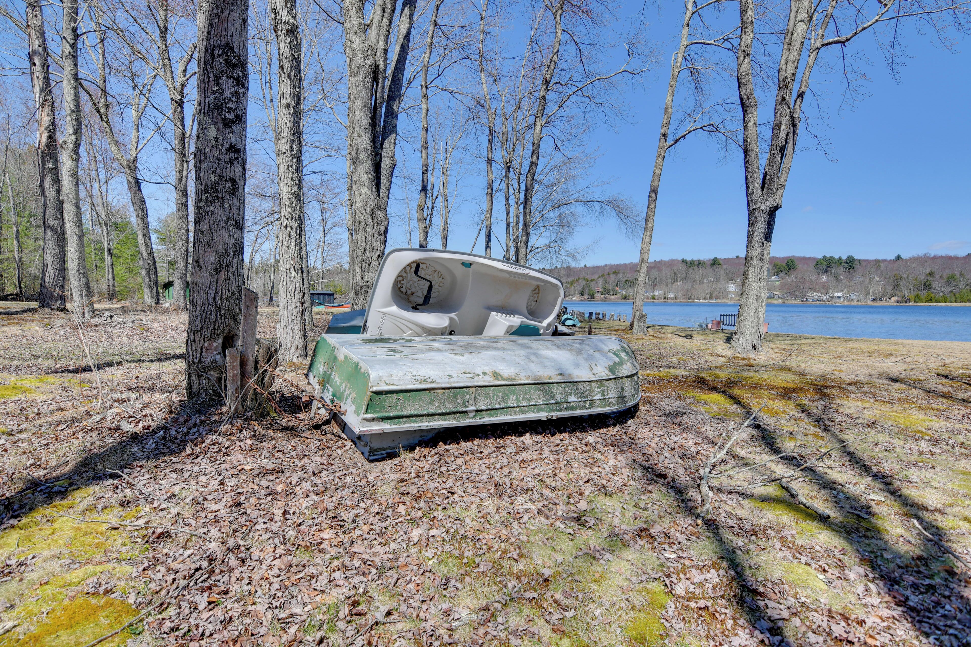 A boat lying on the ground surrounded by trees.