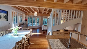 Een houten interieur met een eethoek, trap en keuken.