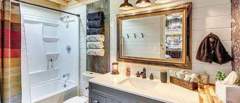 Un bagno con vasca, toilette, lavabo e specchio.