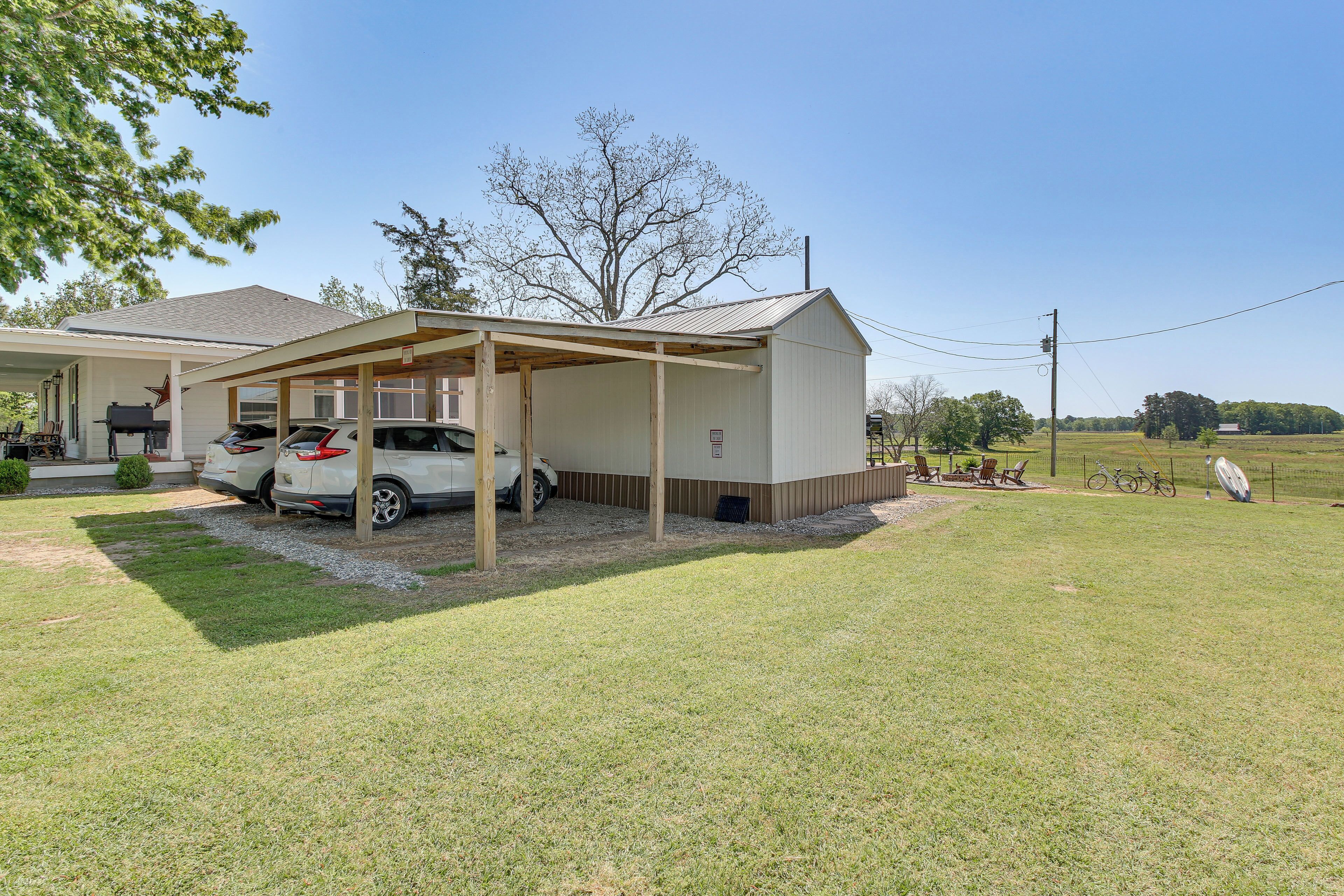 A single-story building with a covered porch, a car parked in front, and a grassy yard.