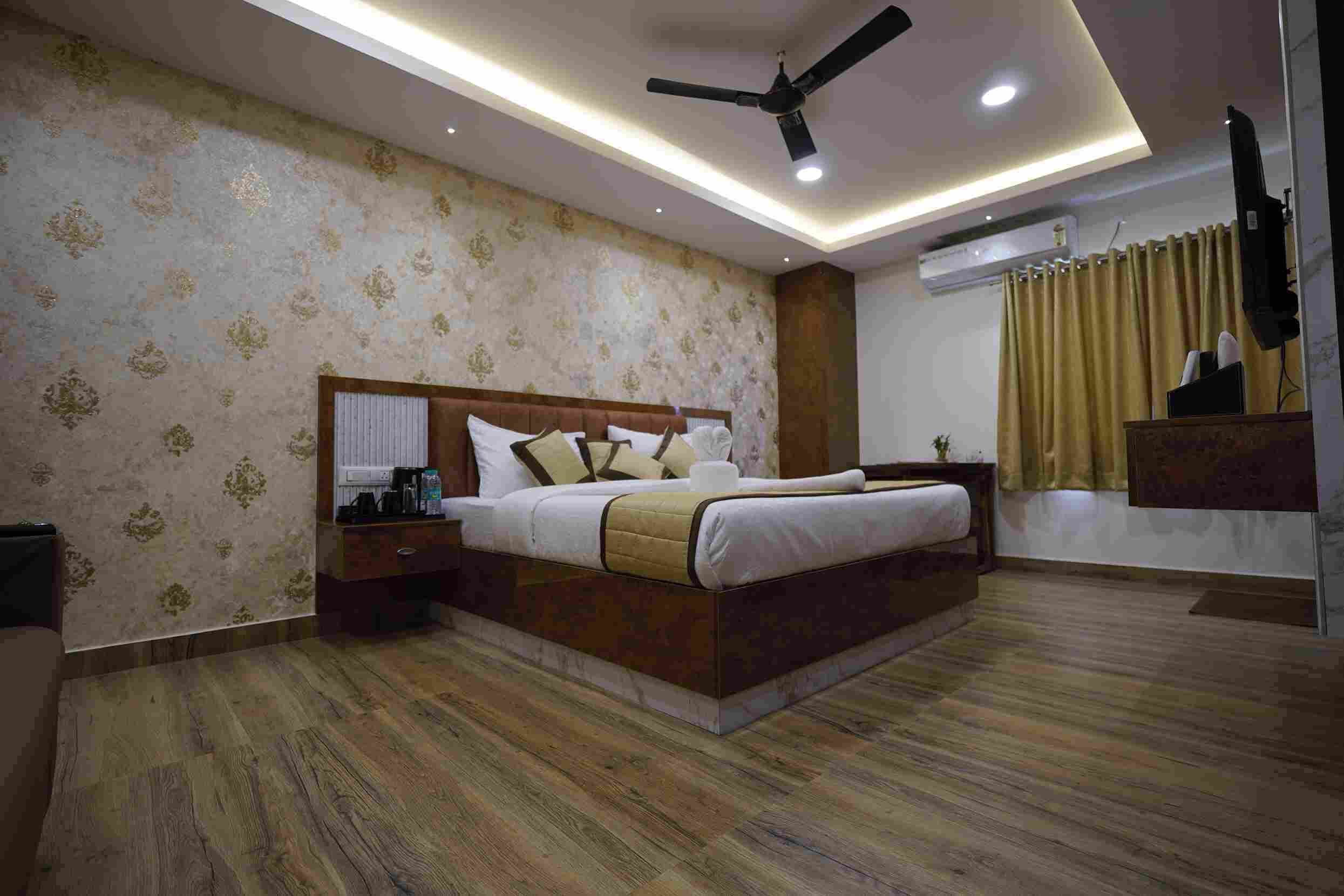 A bedroom with a bed, nightstands, a ceiling fan, recessed lighting, and a television.
