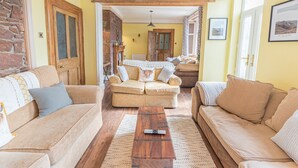 A cozy living room with a fireplace, wooden beams, and a dining area. - 1 Cleator Gate (Cleator)