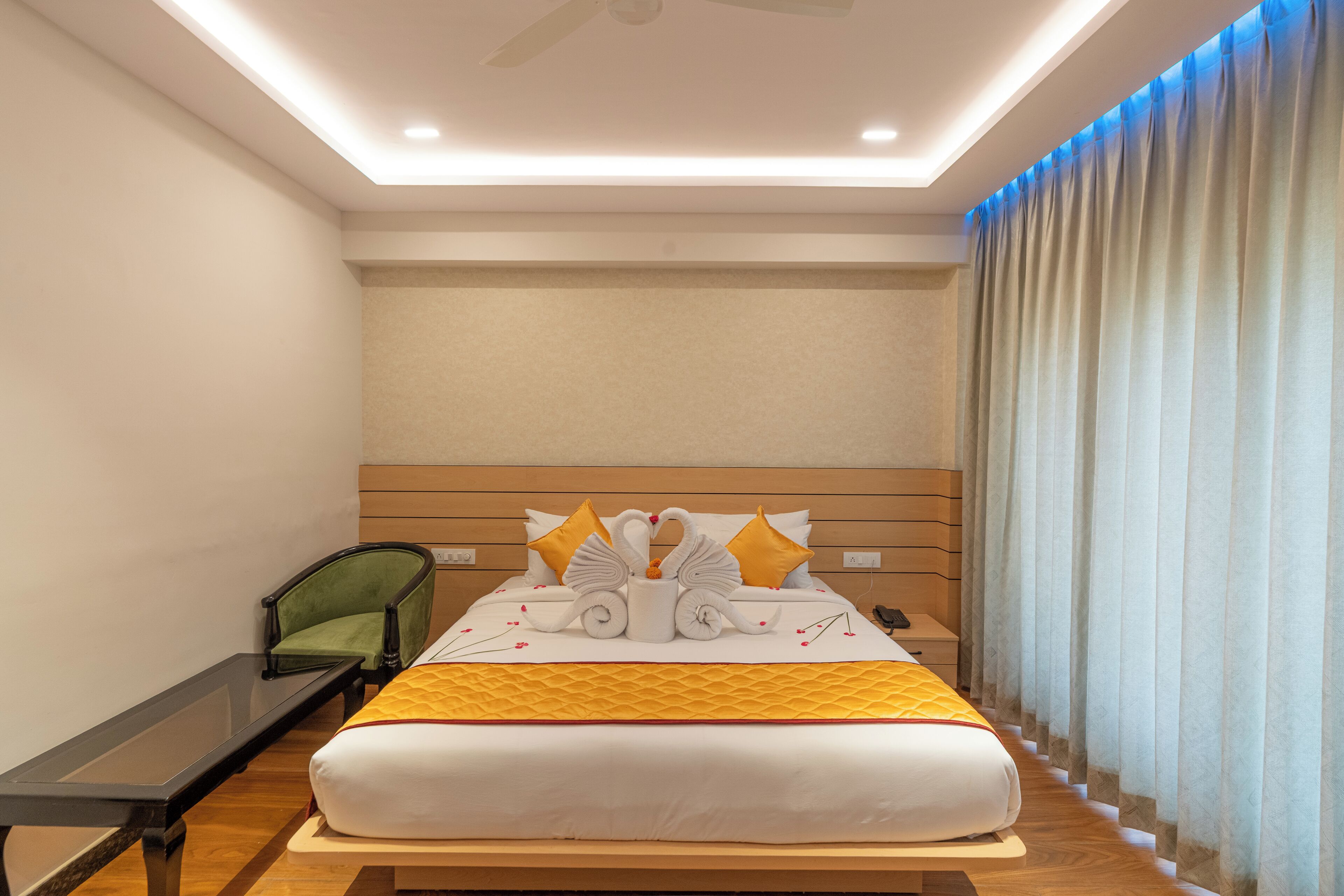 A hotel room with a bed, a nightstand, a chair, and a desk.