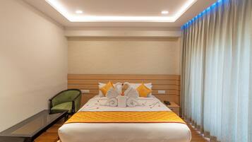 A hotel room with a bed, a nightstand, a chair, and a desk.