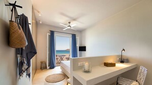 Een moderne hotelkamer met een balkon, een bureau met een lamp en een stoel.